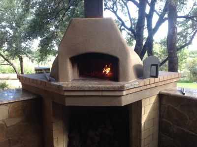 Wood-burning pizza oven with small wood curing fire.