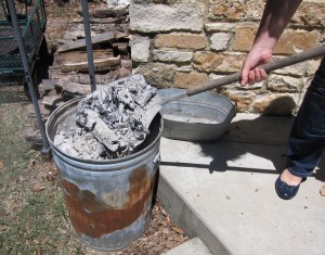 A metal trash can with tight-fitting lid can safely contain coals and ash. 