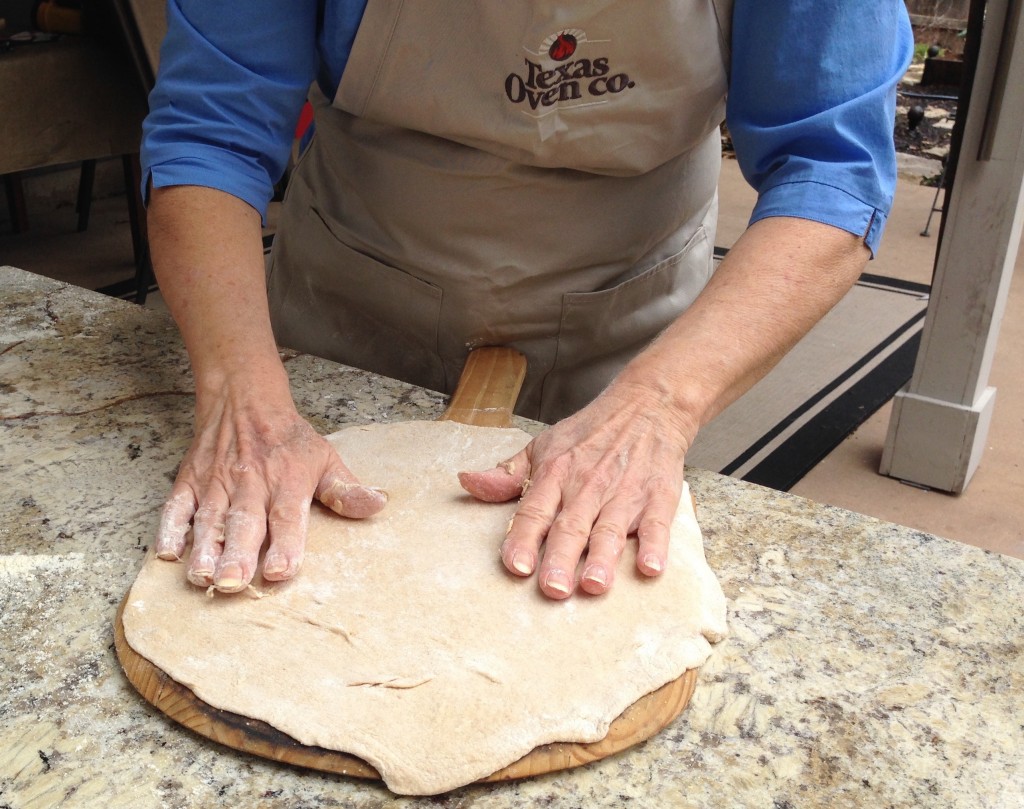 Foolproof-Pizza dough shaped on pizza peel for wood-fired oven pizza oven. 