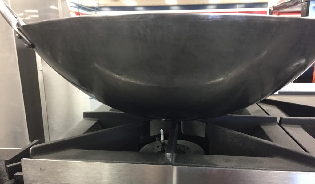 wok pan has minimal surface area  in contact with conventional stove top