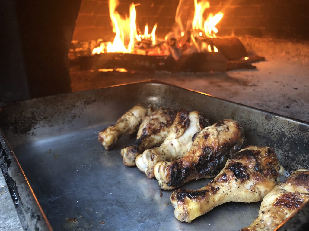 chicken drumsticks in wood-burning oven pizza oven