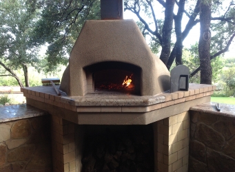 Wood-burning pizza oven with small wood curing fire.